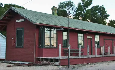 An exterior photo of a red historic building with a green roof.