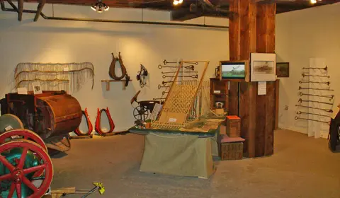 A museum interior displays historical farm equipment and artifacts.