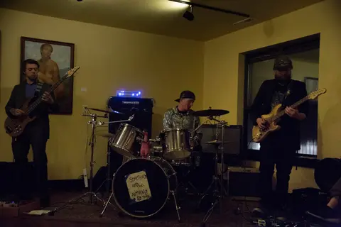 A band performs on stage inside a room.