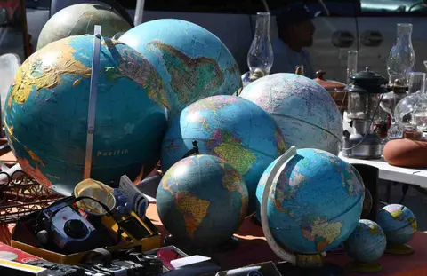 A collection of various globes and other items on display outdoors.