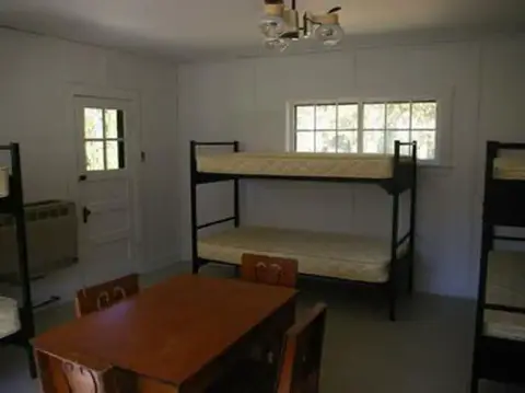 An interior view of a room with bunk beds and a table.