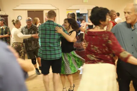 People dancing indoors in a large room.
