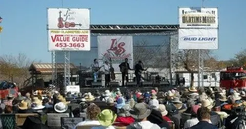 A band performs on an outdoor stage before a crowd.