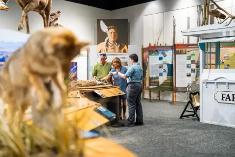 Visitors and a guide explore a museum exhibit.
