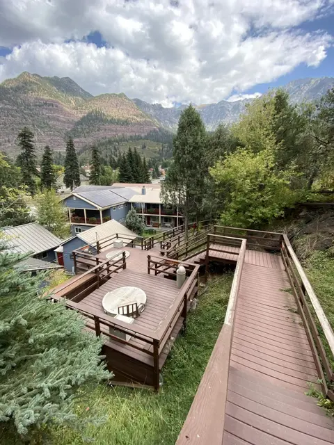 An elevated wooden deck overlooking buildings and mountains.