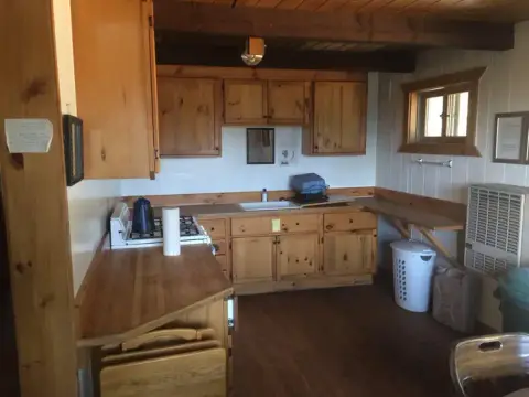 A rustic kitchen interior with wooden cabinets and counters.