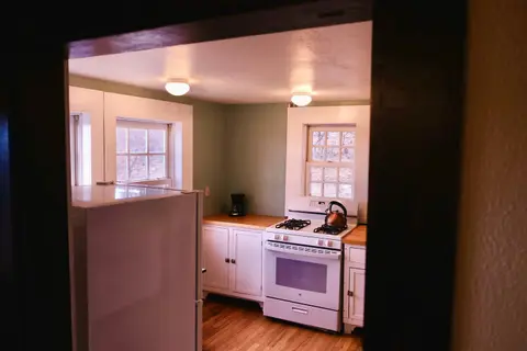 A view of a kitchen with white cabinets and appliances.