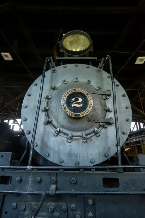 A close-up front view of a historic locomotive.