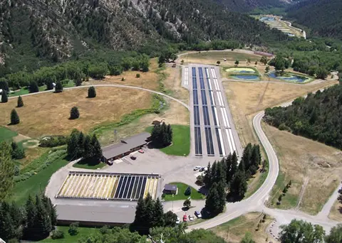 Aerial view of a fish hatchery facility nestled in a valley.