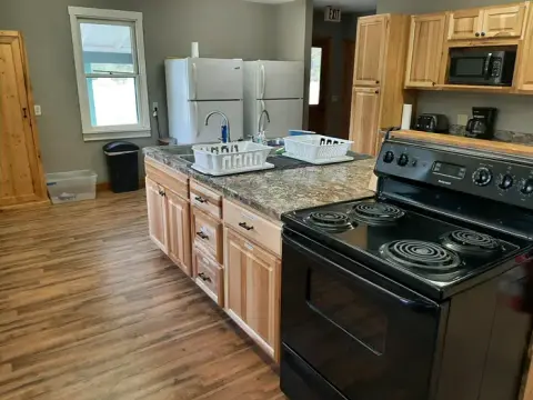 An indoor view of a kitchen with wooden cabinets and a black stove.