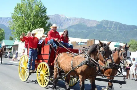 People ride in a horse-drawn wagon during an outdoor event.