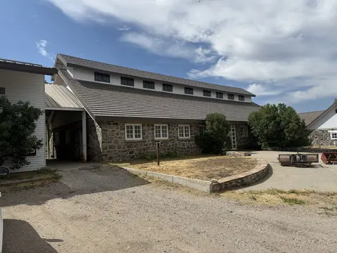 An exterior view of a stone and white building under a cloudy sky.