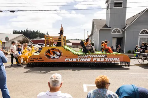 A festival float moves down a street during a parade.