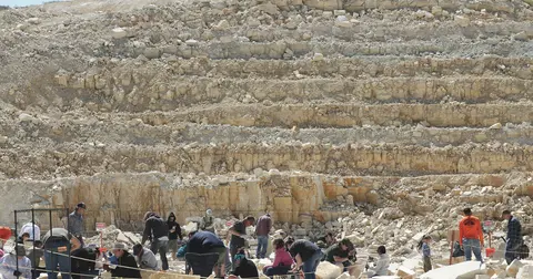 A group of people working in a rocky quarry.