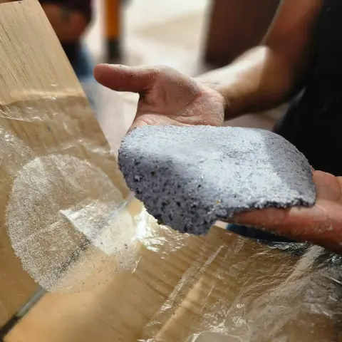 A person holds a freshly pressed blue corn tortilla.