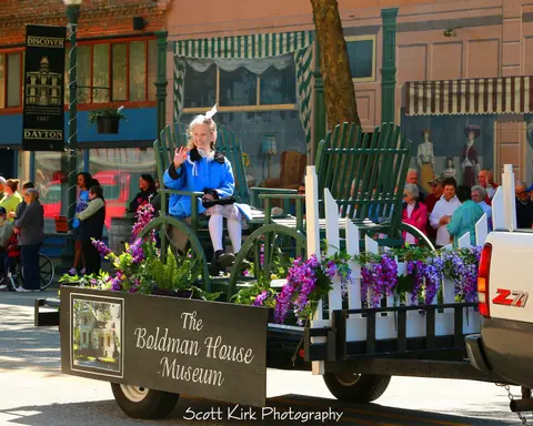 A young girl waves from a decorated parade float.