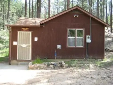 A brown wooden cabin set among trees.