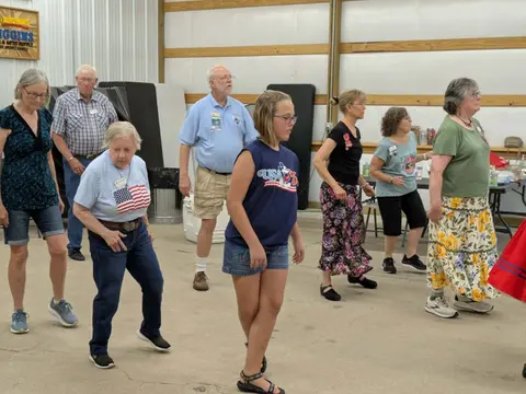 A group of people line dancing indoors.