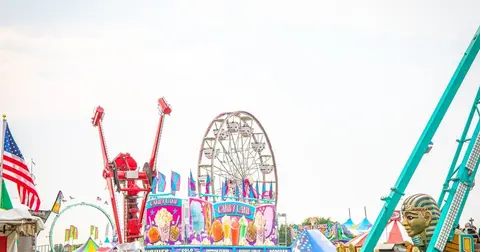 A view of carnival rides and booths at a fair.