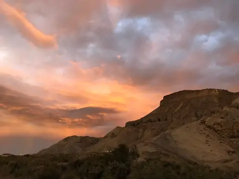 A scenic view of a desert landscape under a colorful sunset sky.
