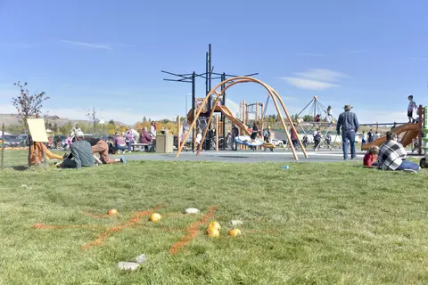 People gather at a playground on a sunny day.