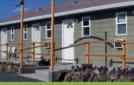 A single-story motel building with multiple doors and windows exterior view.