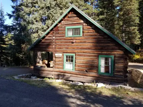 A log cabin surrounded by trees.