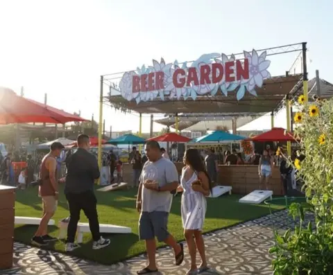 People enjoying themselves in an outdoor beer garden.