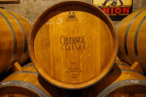 Wooden wine barrels stacked in a cellar.