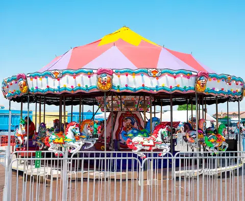 A brightly colored carousel at an outdoor fair.