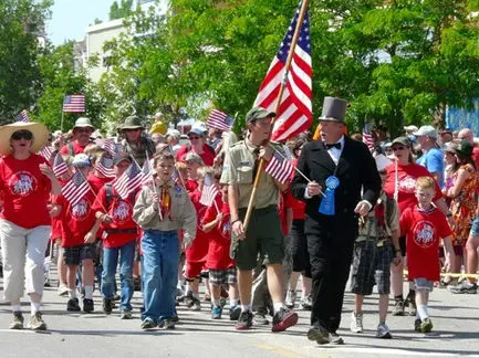 A group of people holding American flags participating in a parade.