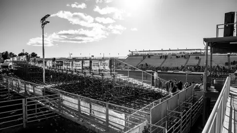 Black and white photograph of rodeo stands and arena.