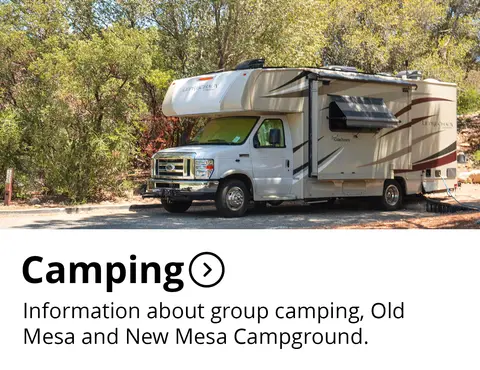 A large motorhome parked in a wooded area with informational text below.