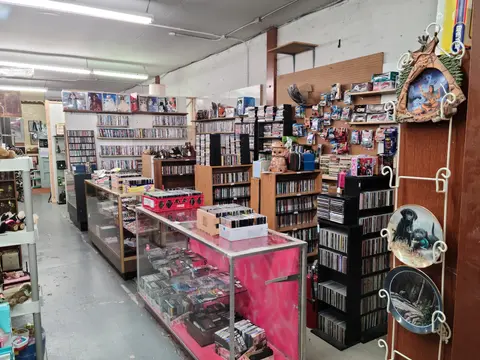 An interior view of a store filled with shelves of CDs, DVDs, and various merchandise.