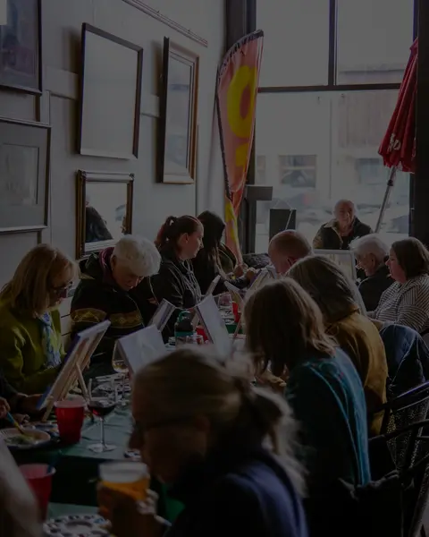 A group of people painting together at a table indoors.