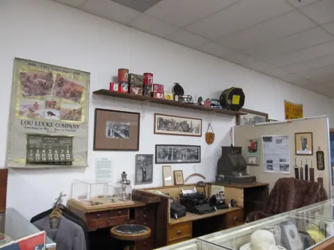 An interior museum display featuring historical items, old photographs, and vintage office equipment.