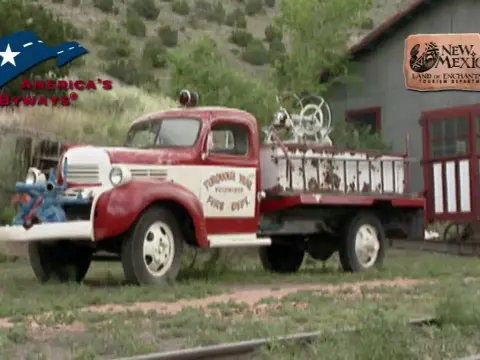 An old red and white fire truck parked outdoors.