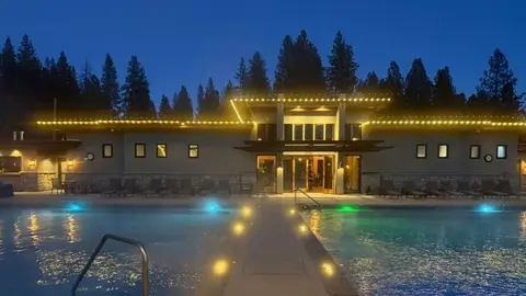 A building and swimming pool illuminated at night.