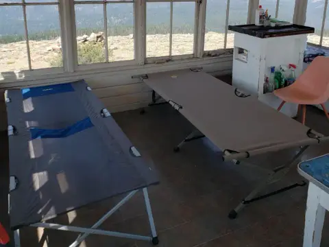 The interior of a lookout tower showing two cots.