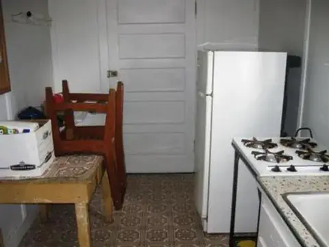 A photo showing the interior of a kitchen with a refrigerator and stove.