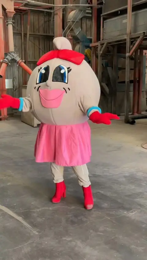 A mascot character stands inside an industrial building.