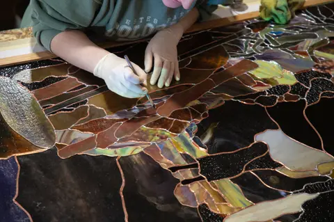 A person working on a stained glass piece.