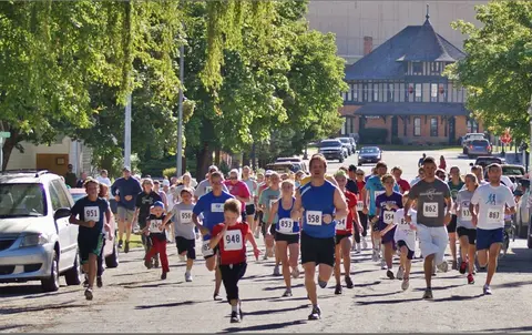 A large group of people running in a race down a city street.