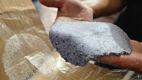 A person holds a piece of handmade blue paper.