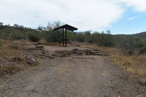 A covered picnic table in a desert landscape.
