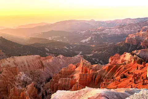 A scenic view of a vast canyon landscape at sunset.