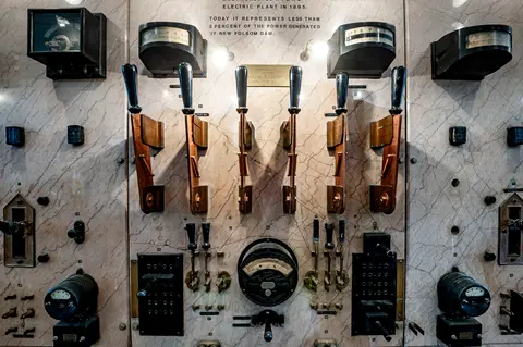 An old marble electrical control panel with levers and gauges.