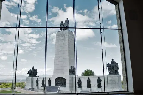 A large stone monument seen through a large window from the inside.