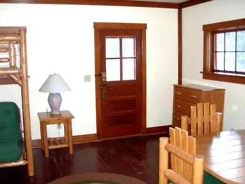 An interior view of a room with wooden furniture and a door.