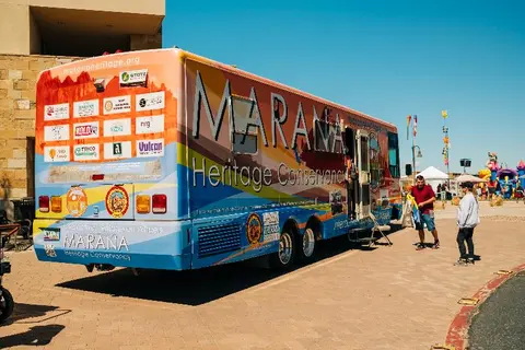 A colorful wrapped motorhome parked outdoors on a paved surface.
